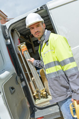 builder taking tools out of his professional truck van