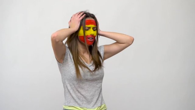 Pretty woman supporter fan of Portugal national team painted flag face get sad lose emotions upset into a camera. Football emotions.