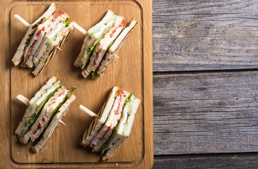 Club sandwich with tomatoes , cucumber , ham and cheese