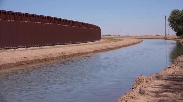 A tributary of the Colorado River flows along the border wall between the US and Mexico.