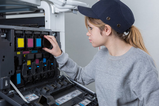 female workers changing ink of a printer
