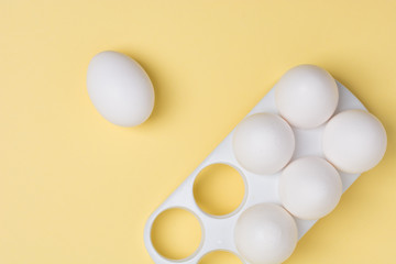 Happy Easter concept. White eggs on yellow background close up. Flat lay. Minimal concept. Top view. Design, visual art.