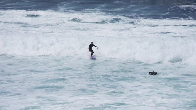 Surfers on foamy waves