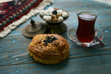 Novruz holiday with Azerbaijan national pastry Gogal and glass of black tea on rustic wooden table background, Delicious dessert holiday food