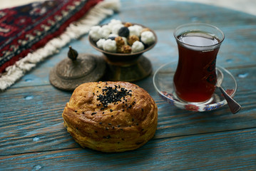 Novruz holiday with Azerbaijan national pastry Gogal and glass of black tea on rustic wooden table background, Delicious dessert holiday food