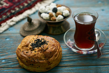 Novruz holiday with Azerbaijan national pastry Gogal and glass of black tea on rustic wooden table background, Delicious dessert holiday food