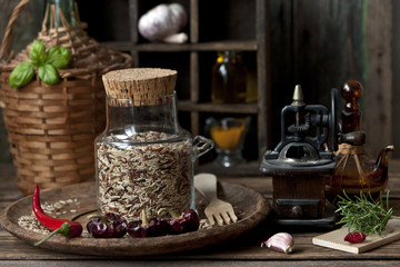 Close-up of mixed rice in glass bottle with garlic and red hot chili pepper on wooden background