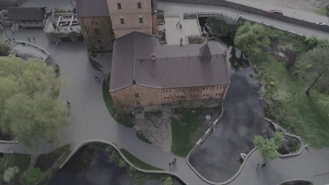 Aerial view of Historical and cultural complex Castle-museum Radomysl- the museum of Ukrainian home icons. Flying around the Radomyshlsky Castle with a view of the surrounding landscapes of the lake