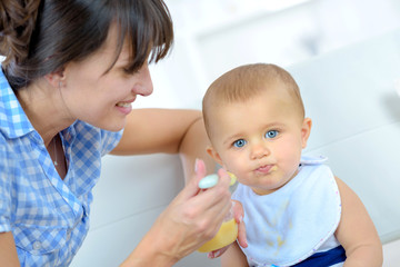 baby eating food on kitchen