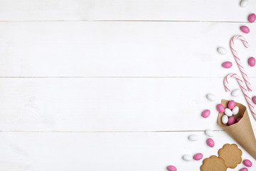Frame Candies and cookies Top view White wooden Background