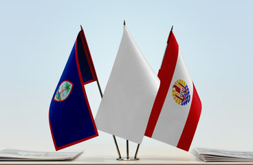 Flags of Guam and French Polynesia with a white flag in the middle