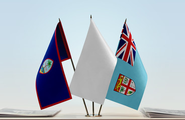 Flags of Guam and Fiji with a white flag in the middle