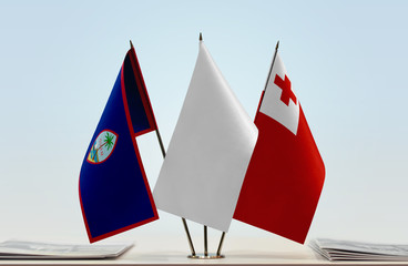 Flags of Guam and Tonga with a white flag in the middle