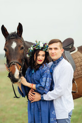 Obraz premium The boyfriend hugs a dreamed girlfriend who holds a horse for a bridle