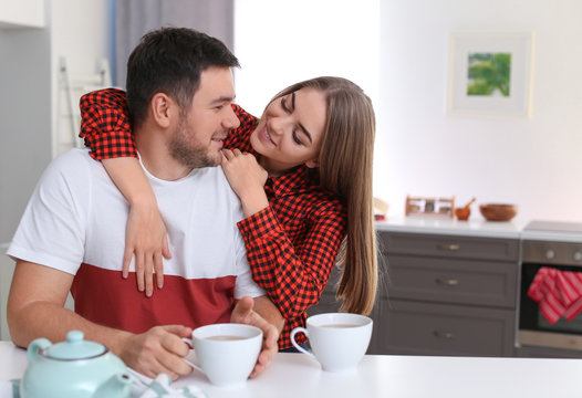 Cute young lovely couple drinking tea in kitchen