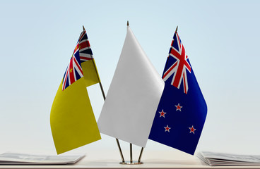 Flags of Niue and New Zealand with a white flag in the middle