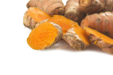 turmeric root and some slices on a white background