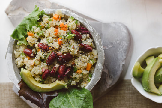 Salad of quinoa, red beans and vegetables, in the bowl, on the table ready to eat