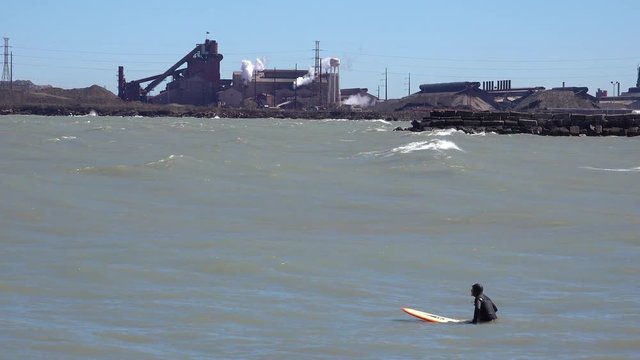 Surfers brave a highly polluted industrial area on Lake Michigan.