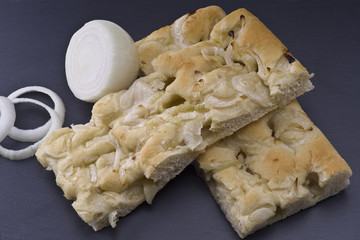white pizza with onions on the slate stone background