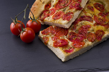 white pizza with tomatoes on the slate stone background