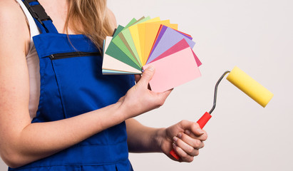 Junge Frau sucht eine Farbe aus um die Wand zu streichen