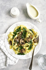 Tagliatelle pasta with spinach and mushrooms served with cream sauce beachamel.Top view.