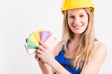 Junge Frau sucht eine Farbe aus um die Wand zu streichen