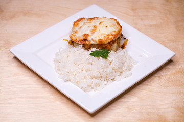 Boiled rice and a chicken cutlet on a white plate
