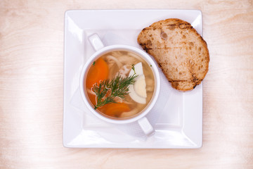 Chicken noodle soup in a white cup