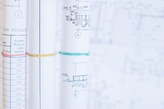 Rolls of drawings. Selective focus on the design drawings. Bright light for desktop engineer