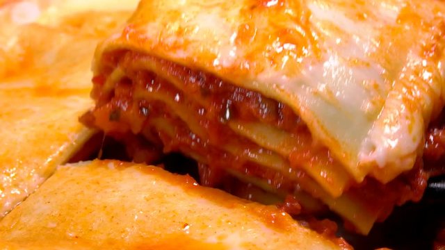 Super close-up cuts off a piece of the delicious Italian lasagna
