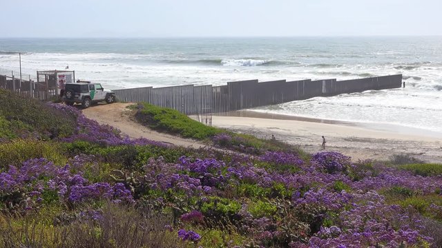 A Border Patrol vehicle looks on as waves roll into the beach at the U.S. Mexico border fence in the Pacific Ocean between San Diego and Tijuana.