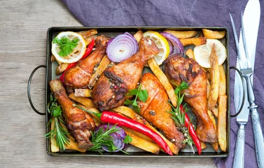 Foto auf Acrylglas Grilled spicy chicken legs with pepper, lemon and potatoes © Inna