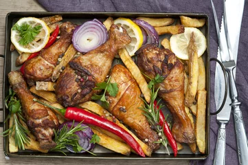 Foto auf Acrylglas Grilled spicy chicken legs with pepper, lemon and potatoes © Inna