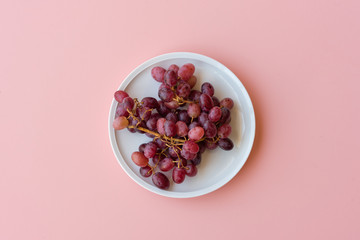 Directly above view of red grapes on pink background