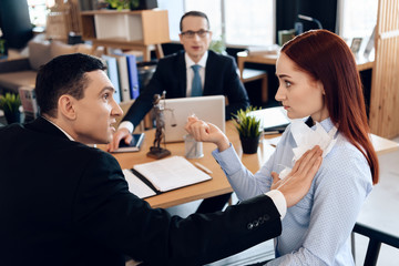 Disgruntled adult man pokes torn marriage contract into red-haired woman in divorce lawyer's office.