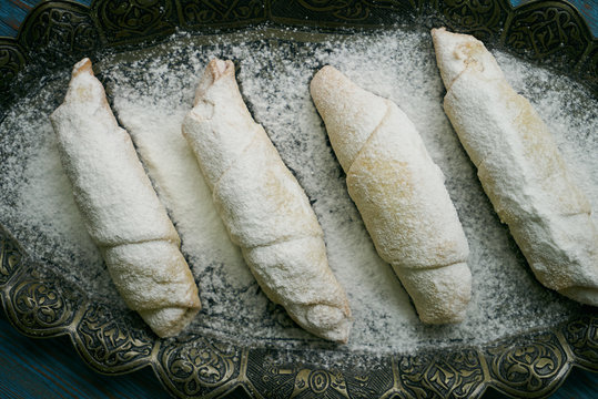 Biscuits with walnuts and sugar powder, oriental sweets mutaki pastry on rustic wooden blue table background, close-up