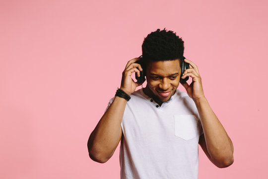 Portrait of a smiling young DJ enjoying listening to music
