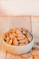 almonds in wood cup on table.