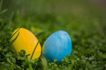 Yellow and white Easter eggs on the leaves of the clover. Easter background. Celebration of Easter in Ukraine.