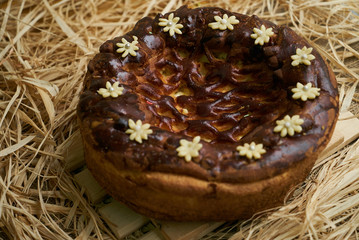 Traditional Ukrainian wedding bread korovai or karavai with decorations on rustic straw background. 