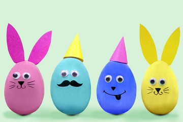 Happy Easter concept. Colorful easter eggs with comic fun faces on blue background