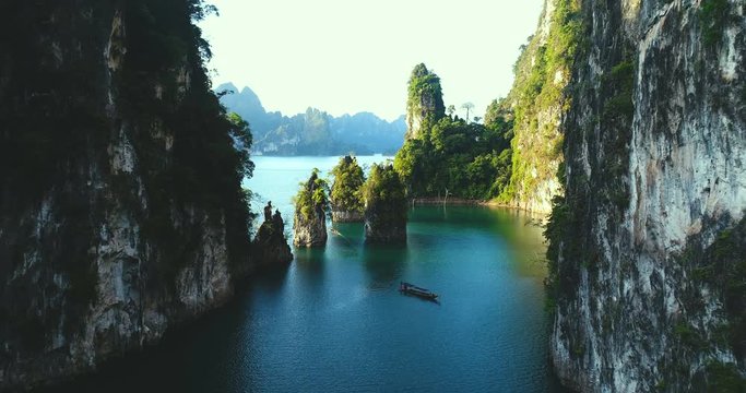 Aerial drone view of beautiful limestone rocks and boat at the lake in Khao Sok National Park, Surat Thani, Thailand
