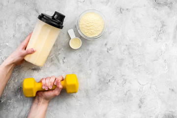 nutrition for workout with protein cocktail, powder and bars on stone background top view mockup