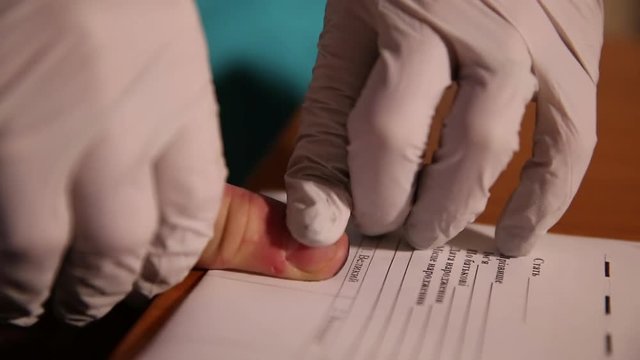 A man is being fingerprinted. Taking fingerprints from suspect. Closeup