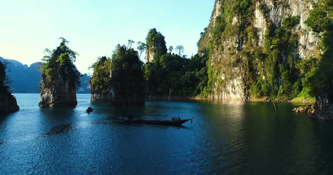 Aerial drone view of beautiful limestone rocks and boat at the lake in Khao Sok National Park, Surat Thani, Thailand