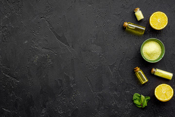 Natural cosmetics set with fresh lemon and organic oil on black background top view mock up
