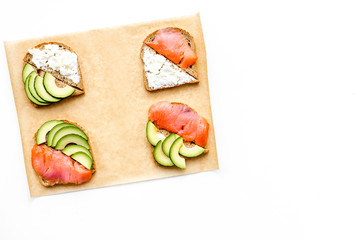 homemade sandwiches with french baguette, salmon, cheese and vegetable on white background top view mock-up