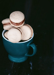 tasty dessert in a green mug, delicious  makaroons, beautifully in a row is located, the taste is evident